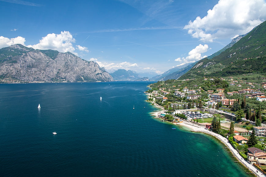 Aerial view of Lake Garda coastline with mountains and boats