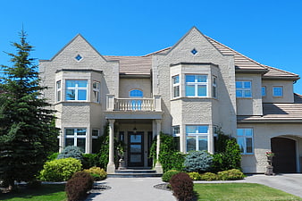 Luxury beige stone house exterior with manicured landscaping