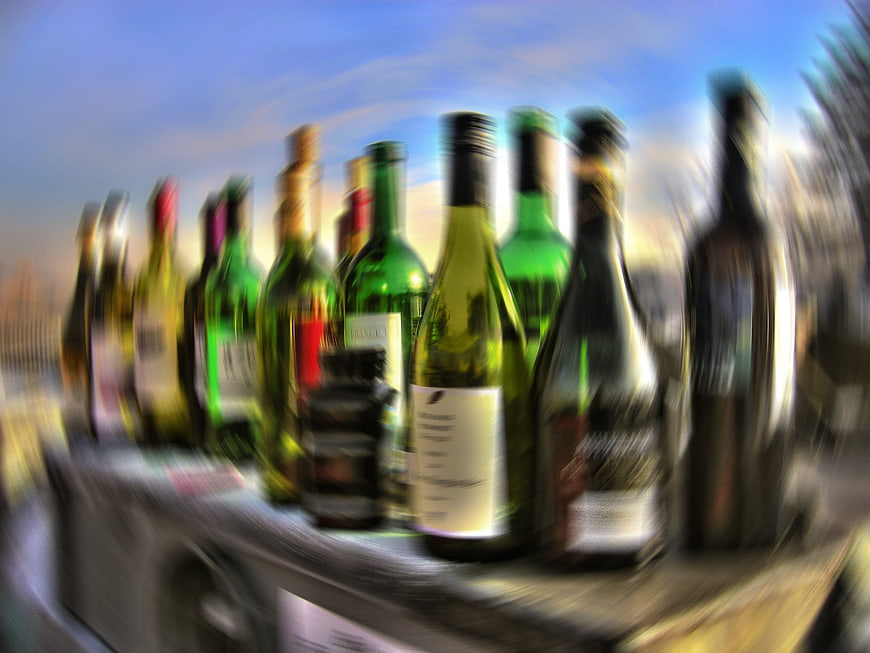 Blurred row of wine bottles on a table outdoors