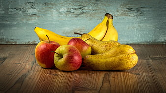 Fresh apples, bananas, and pears on rustic wooden table