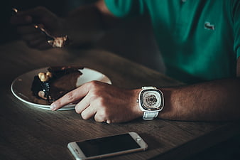 Man Wearing White Watch Eating Chocolate Cake at Wooden Table