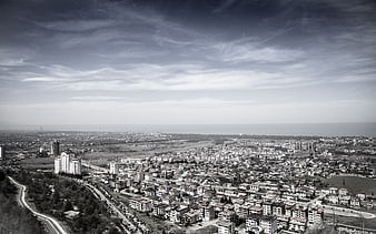 Black and white aerial view of coastal city with winding road