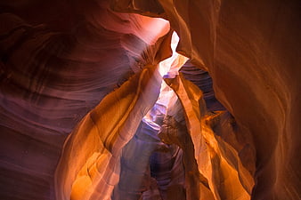 Sunlight streaming through swirling sandstone walls of Antelope Canyon