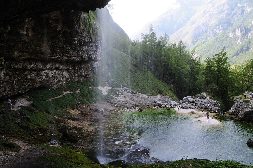 Waterfall cascading into a pool in a mountain valley