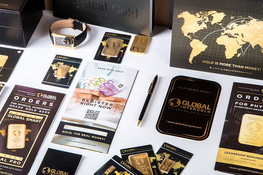 Gold investment marketing materials and gold bars flat lay
