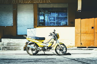 Yellow Motorcycle Parked on Sunny Street