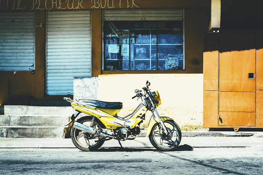 Yellow Motorcycle Parked on Sunny Street