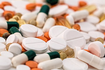 Close-up of assorted pills and capsules on white background