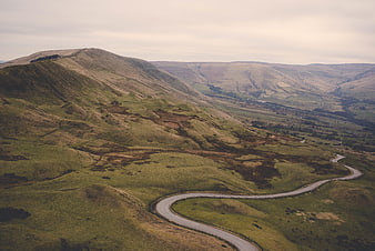 Winding road through rolling green hills and mountains