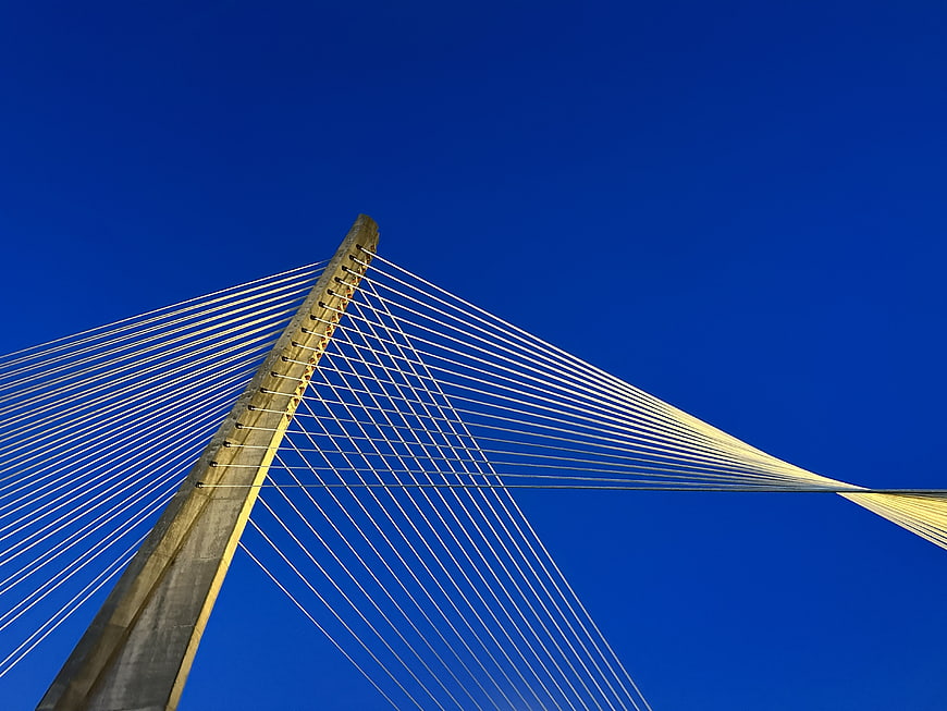 Low angle view of cable-stayed bridge tower against blue sky