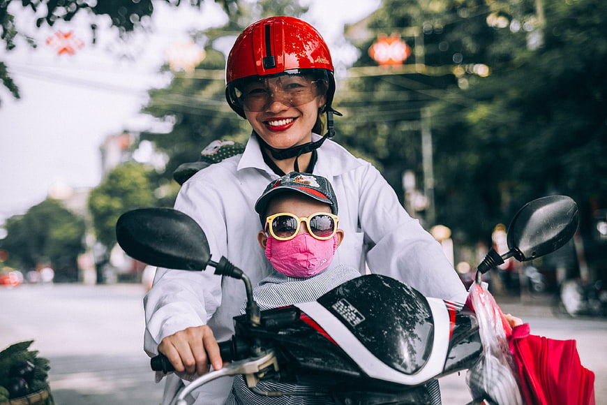 Happy Mother and Child Riding Scooter on Street
