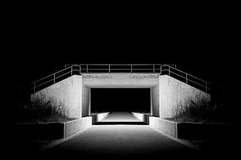 Black and white night photo of a concrete underpass