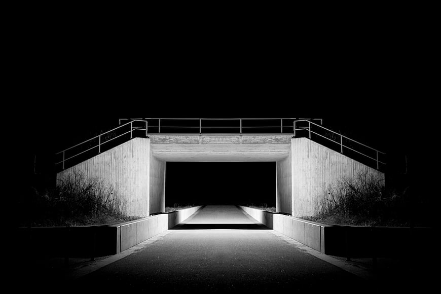 Black and white night photo of a concrete underpass
