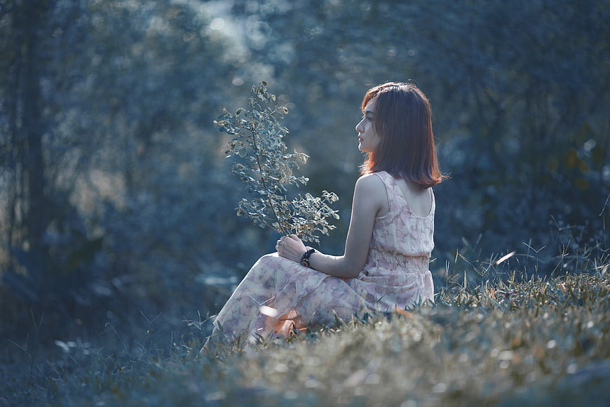 Woman in Pink Dress Sitting in Forest with Branch