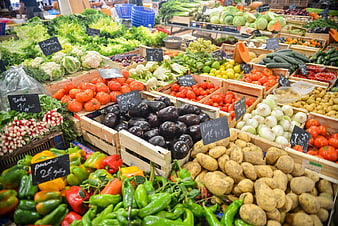 Fresh organic vegetables displayed in wooden crates at a bustling market
