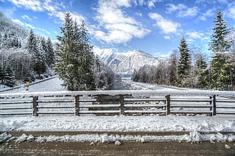 Snowy winter landscape with railway tracks and mountains