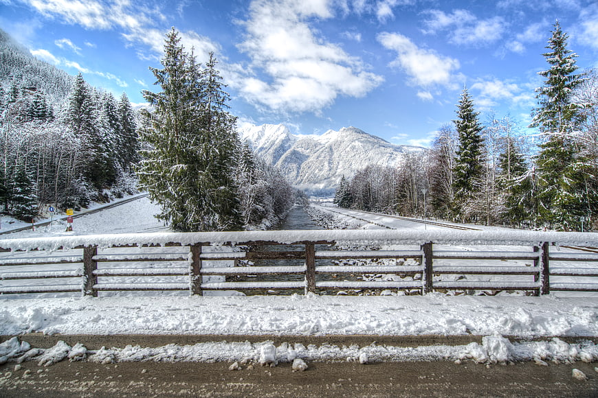 Snowy winter landscape with railway tracks and mountains