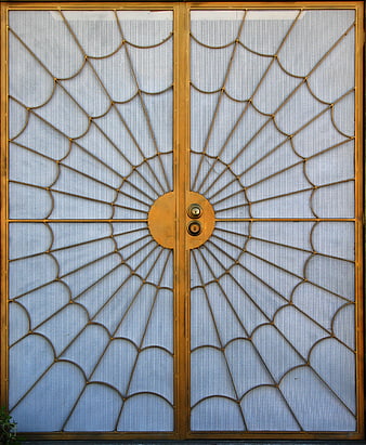 Golden metal door with intricate spiderweb radial design