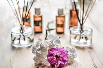 Aromatherapy diffusers and fresh flowers on wooden table