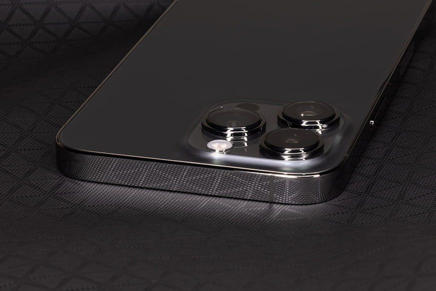 Close-up of black smartphone camera module on textured surface