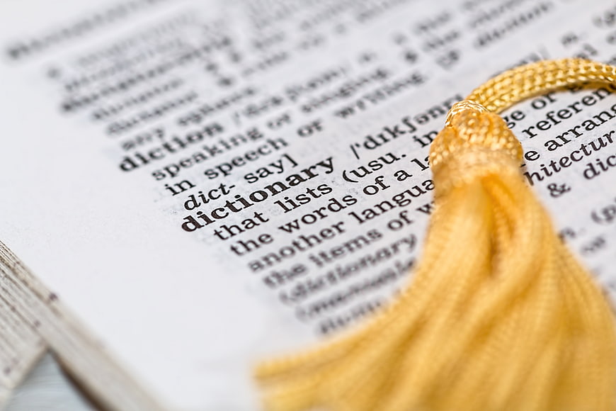 Close-up of dictionary page with yellow tassel bookmark
