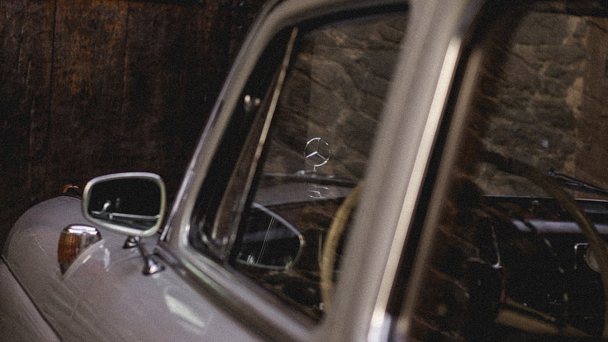 Close-up of vintage Mercedes-Benz hood ornament and side mirror