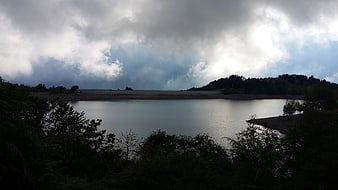Dramatic cloudy sky over a reservoir lake in Liguria, Italy