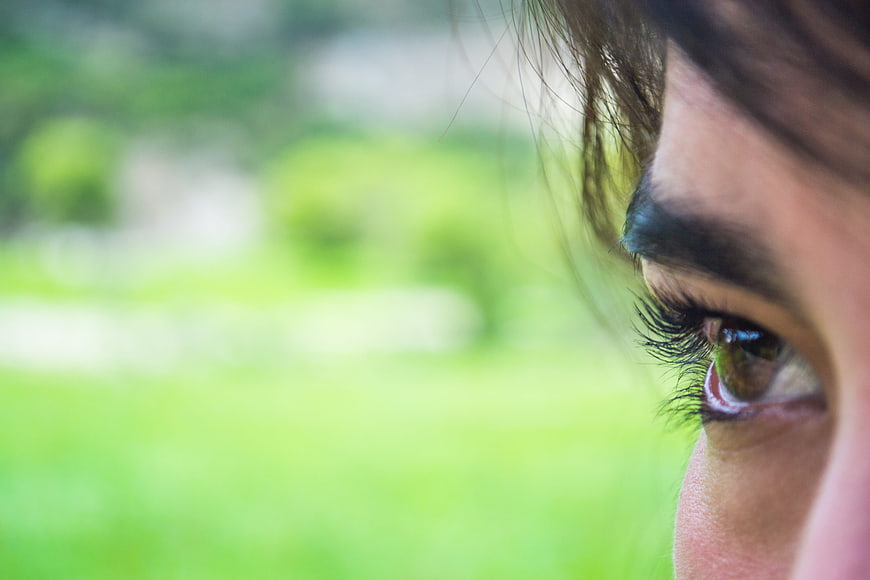 Close-up of a woman's eye with green background