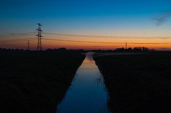 Misty Canal at Sunset with Power Lines
