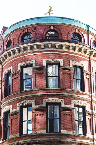 Red Brick Corner Building with Ornate Windows and Weathervane