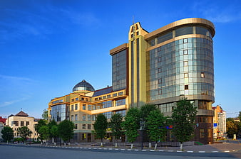 Modern glass and yellow office building with blue sky