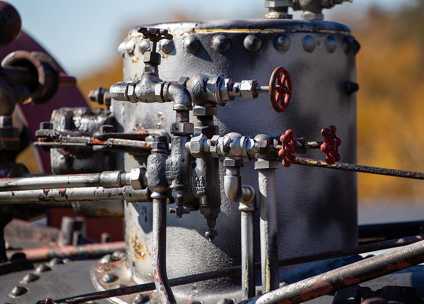 Close-up of vintage industrial pipes and valves on a metal tank