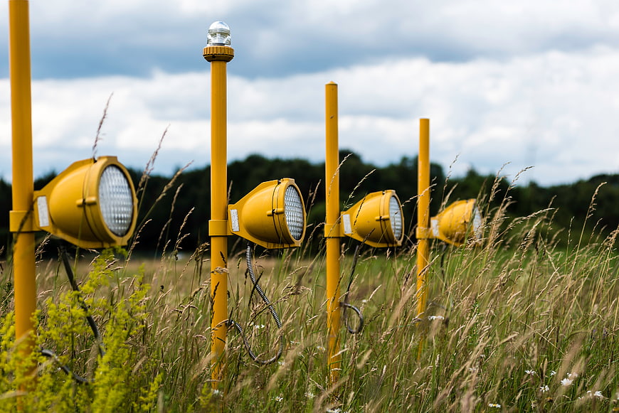 Yellow floodlights in tall grass field