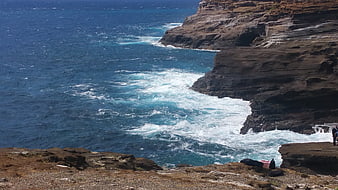 Dramatic ocean waves crashing against rugged coastal cliffs