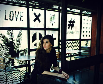 Woman sitting in cafe with graphic window decals