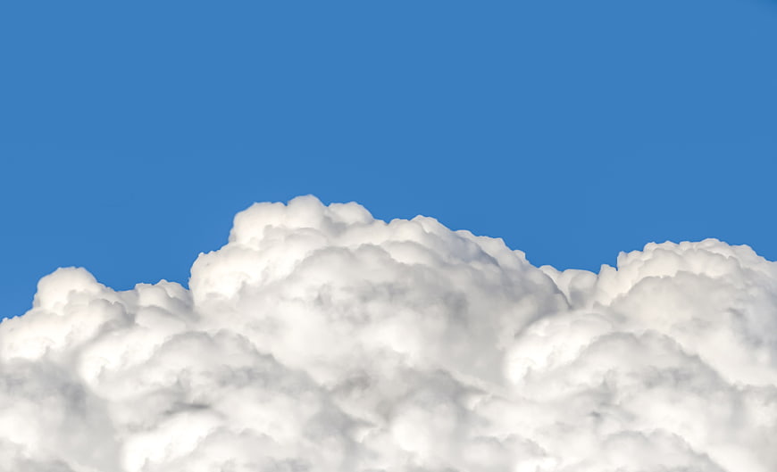 Fluffy white cumulus clouds against a clear blue sky