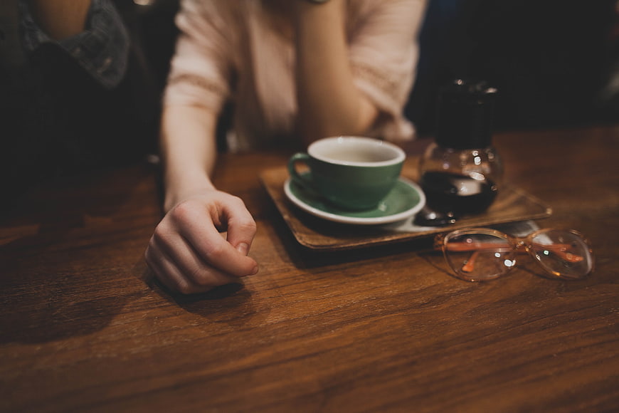 Cozy coffee cup and glasses on wooden table