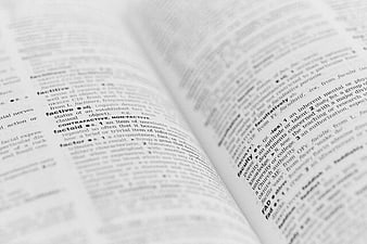 Close-up of open dictionary page with definitions