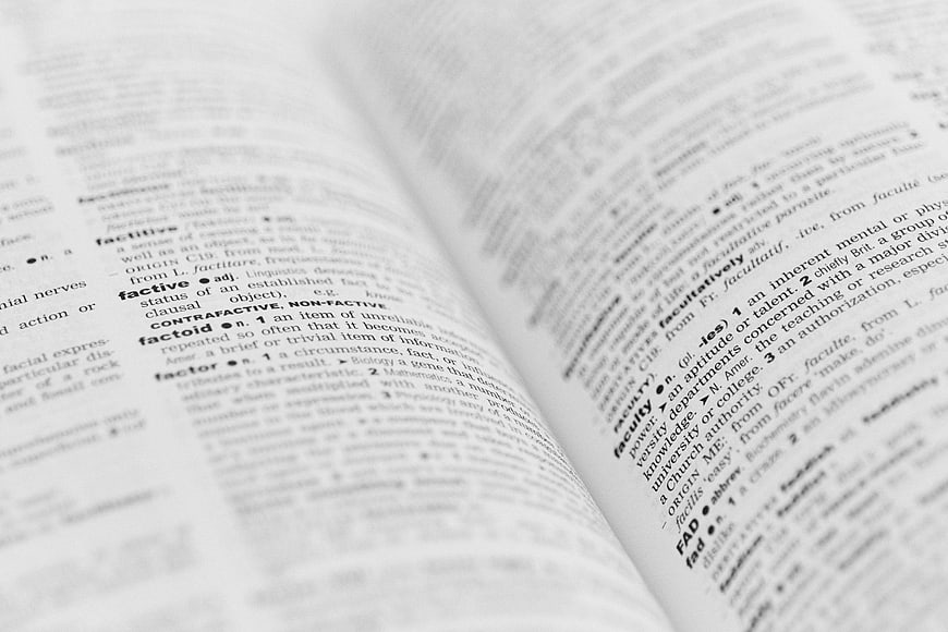 Close-up of open dictionary page with definitions