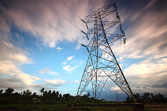 High Voltage Transmission Tower Against Dramatic Cloudy Sky