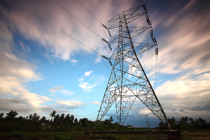 High Voltage Transmission Tower Against Dramatic Cloudy Sky