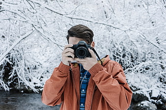 Man Taking Photo with DSLR Camera in Snowy Winter Forest
