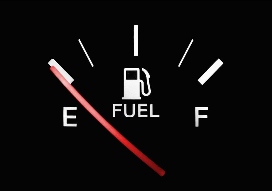 Car fuel gauge showing empty tank on black background