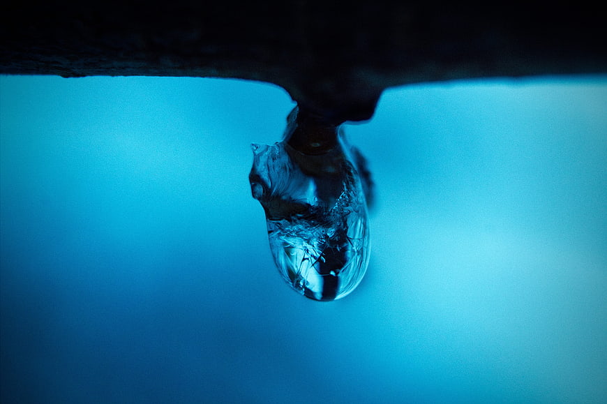 Macro shot of a frozen icicle hanging against a blue background