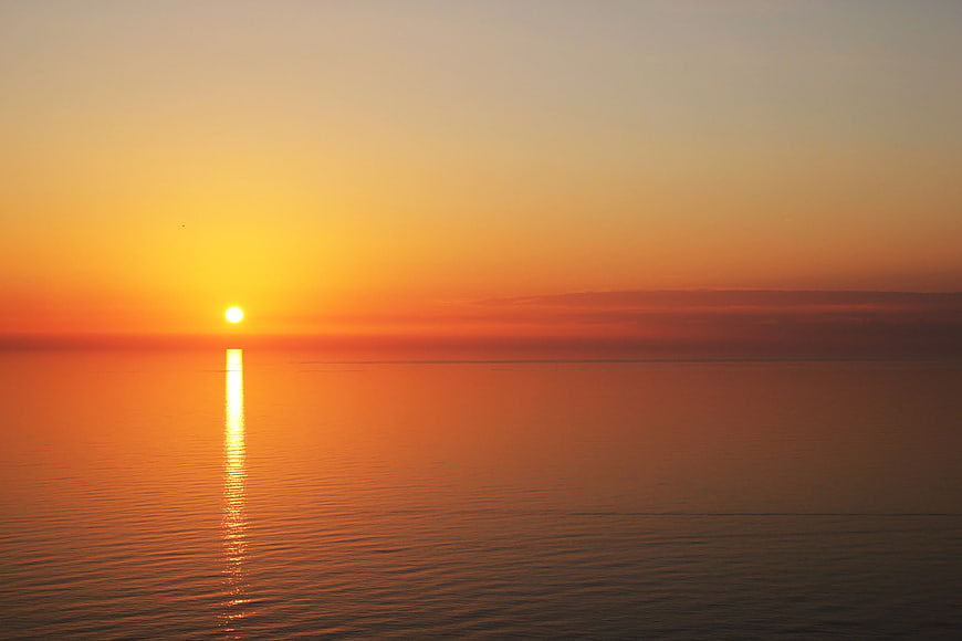 Serene Sunset Over Calm Ocean Water