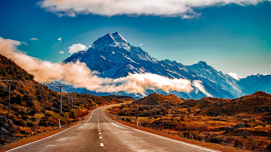Winding road leading to majestic snow-capped mountain peak