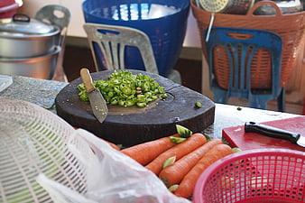 Chopped green chilies and carrots on wooden cutting board