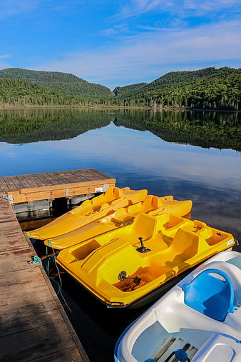 Yellow Pedal Boats Docked at Serene Lake with Mountain Reflections