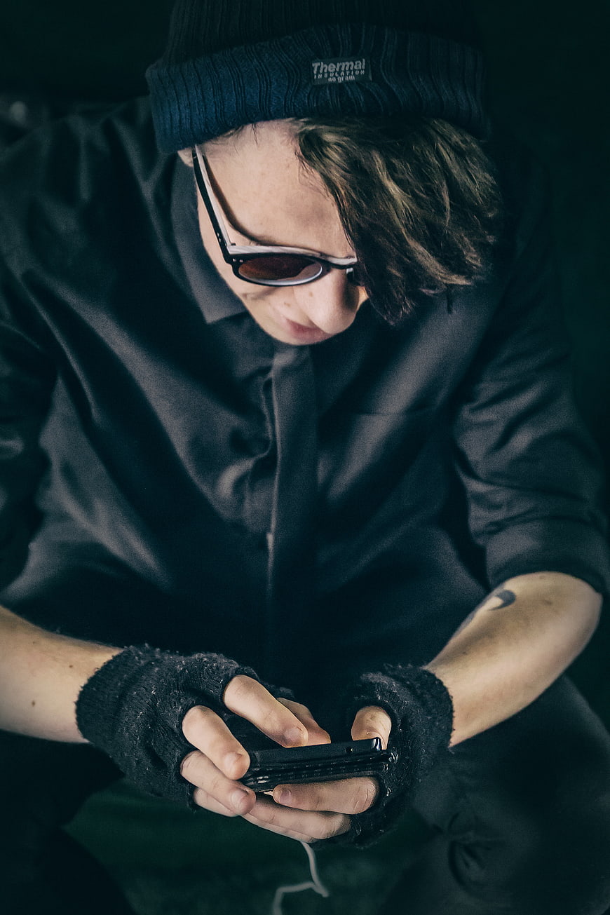 Man in Beanie and Fingerless Gloves Using Smartphone