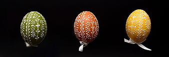 Three Decorated Easter Eggs With White Floral Patterns On Black Background